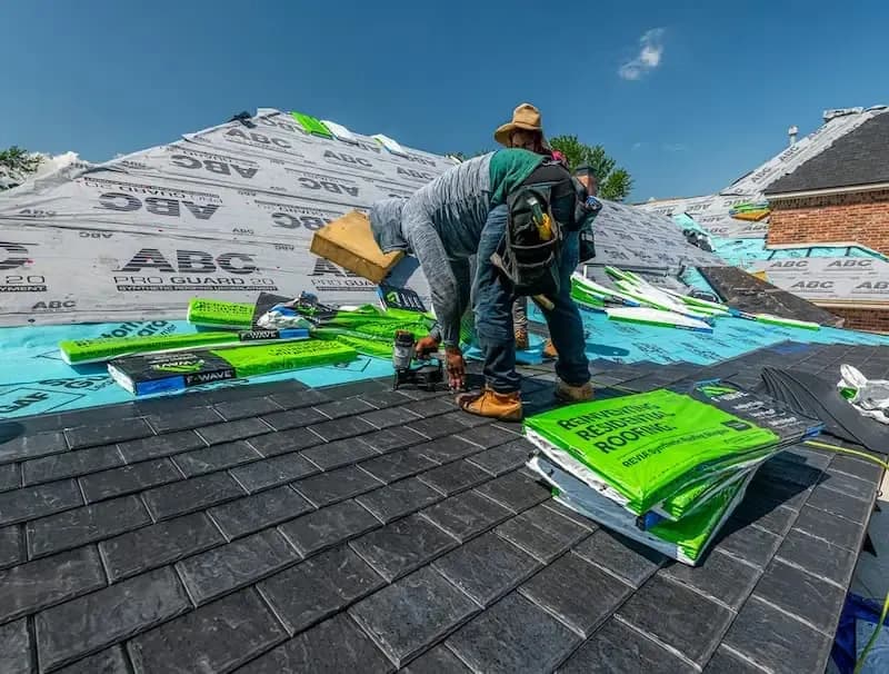 Roofer installing synthetic underlayment