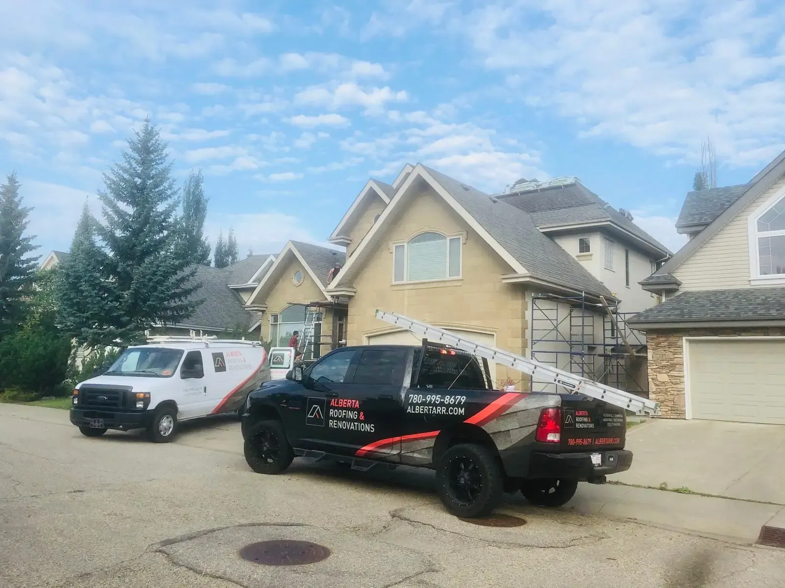 Roofing crew vehicles outside a home during a roof replacement