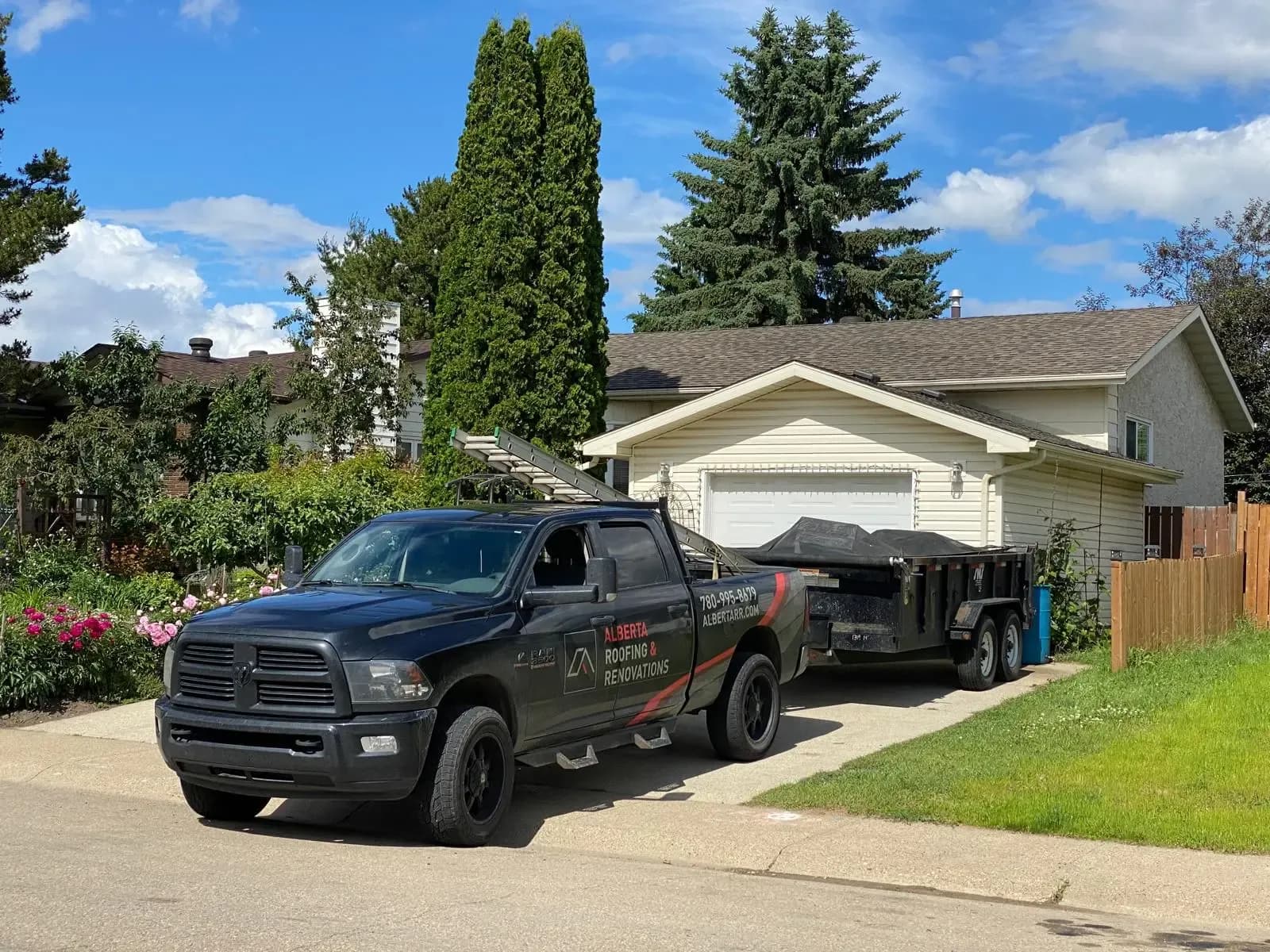 Company truck and trailer outside a home roofing job