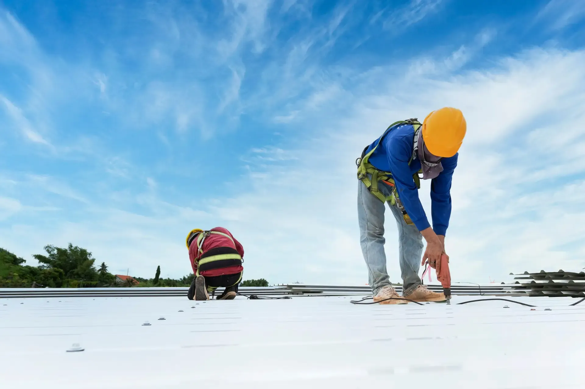 Roofers working on a white membrane commercial roof