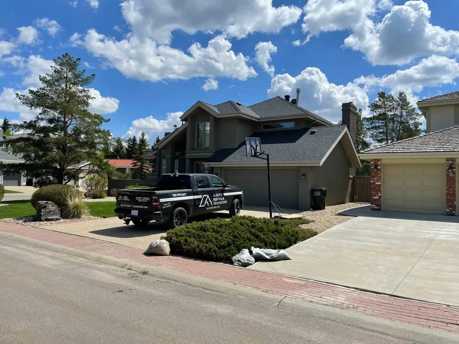 Two-storey home with a new roof and the company truck parked out front